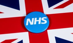 U.K. flag with button saying "NHS" on it.